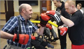  ??  ?? The Meadows resident Lucien Auger hits a punching pad held out by Derek Smout of the Counterpun­ch Boxing Academy.