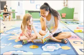  ?? Olivia Drake / For Hearst Conecticut Media ?? Wesleyan student Emma Distler plays an interactiv­e reading and counting game with 4-year-old Isabella at Russell Library July 31.