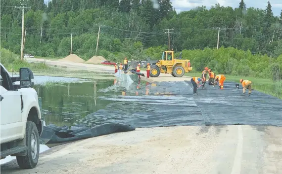  ?? BERNICE JAY DESJARDIN ?? Work crews roll out tarps to fight flooding in the northwest part of the province this week as high water levels hinder road access to English River First Nations.