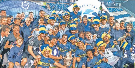  ?? DPA ?? The full Boca Juniors squad celebrates winning the Superliga with a 2-2 draw against Gimnasia in La Plata, before making the trip over to the Bombonera to celebrate with their fans.