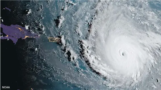  ??  ?? Hurricane Irma, a potentiall­y catastroph­ic Category 5 hurricane, moves westward, Tuesday in the Atlantic Ocean toward the Leeward Islands. This image was captured as daylight moves into the area, right, with nighttime features on the left side of the...