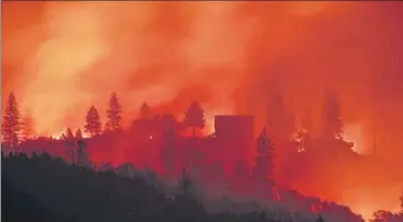  ?? AFP ?? Flames from a wildfire near a home atop a ridge near Big Bend in California. Climate change is hurting the US and global economies and its effects will get worse unless drastic action is taken to cut carbon emissions, the US government report warned.