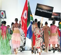  ?? Picture: Masi Losi ?? Models carry banners and flags during the Proudly South African Buy Local Summit and Expo Grand Finale Fashion Show at the Sandton Convention Centre.