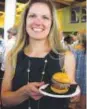  ??  ?? Carrie Eckstein with a hamburger from Hopdoddy Burger Bar.