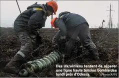  ?? (Photo AFP) ?? Des Ukrainiens tentant de réparer une ligne haute tension bombardée lundi près d’odessa.