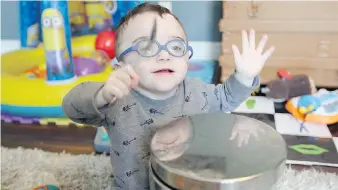  ??  ?? Toddler Luke Harnick uses a tablespoon to make some noise at the family’s Bernard Street home.