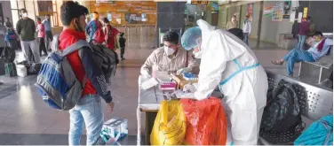  ?? Agence France-presse ?? ↑
Medical workers get ready to take swab samples of passengers arriving from other cities for a virus test in New Delhi on Thursday.