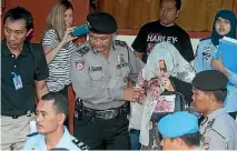  ??  ?? Schapelle Corby emerges from the scrum at Denpasar airport, moments before boarding a flight to Australia.