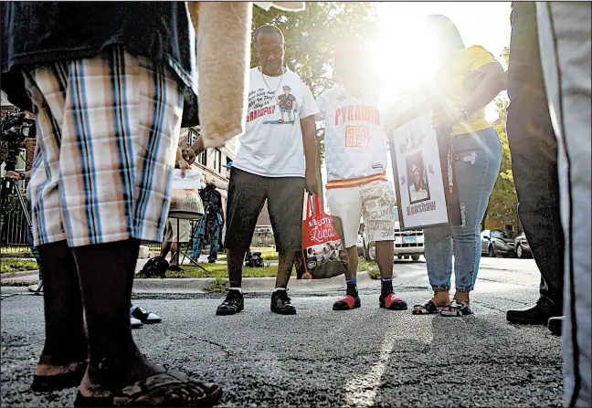 ?? BRIAN CASSELLA/CHICAGO TRIBUNE ?? Family members gather in prayer on July 19 after a shooting injured three family members, including two boys, in the 8200 block of South Ada Street.