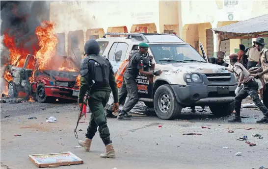  ?? Photo: REUTERS ?? Suicide bombing: Police and soldiers remove a vehicle after a car bomb exploded in Gombe, Nigeria, just after President Goodluck Jonathan left a political rally nearby. Two people were killed.