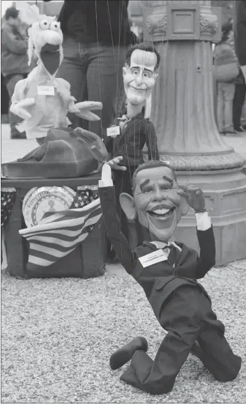  ?? — GETTY IMAGES ?? Puppeteers manipulate likenesses of Barack Obama and Mitt Romney on Friday in Washington.