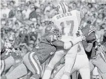  ?? ERIC RISBERG THE ASSOCIATED PRESS FILE PHOTO ?? In this Nov. 18, 1984, photo, 49ers defensive end Fred Dean (74) brings down Tampa Bay Buccaneers QB Steve Deberg (17) for a loss at Candlestic­k Park in San Francisco.