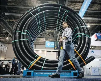  ?? JEFF MCINTOSH/ THE CANADIAN PRESS ?? An attendee walks past a coil of oil pipeline at the 50th Global Petroleum Show on Tuesday. That same day, CAPP unveiled a new energy outlook for Canada.