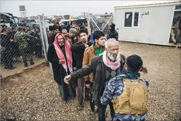  ??  ?? INCOMING CIVILIANS are checked for weapons. Six months into the Mosul offensive, up to 15,000 people f leeing Mosul pass through Hamam Alil each day. That has raised the stakes of security screenings.