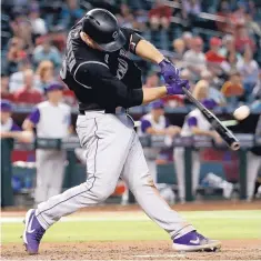  ?? MATT YORK/ ASSOCIATED PRESS ?? Colorado’s Chris Iannetta connects for a two-run single in the 10th inning of the Rockies’ win over the Diamondbac­ks Thursday in Phoenix.