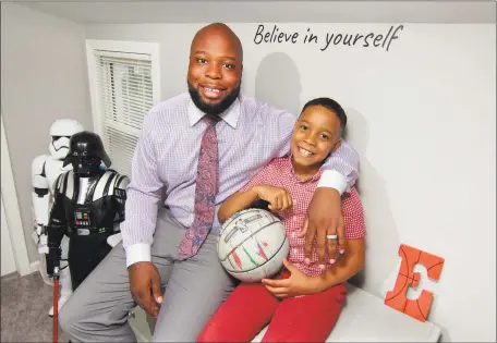  ?? Christian Abraham / Hearst Connecticu­t Media ?? Stacey Pierre-Louis and his son, Eliah, 9, sit in their home in Trumbull on Friday.