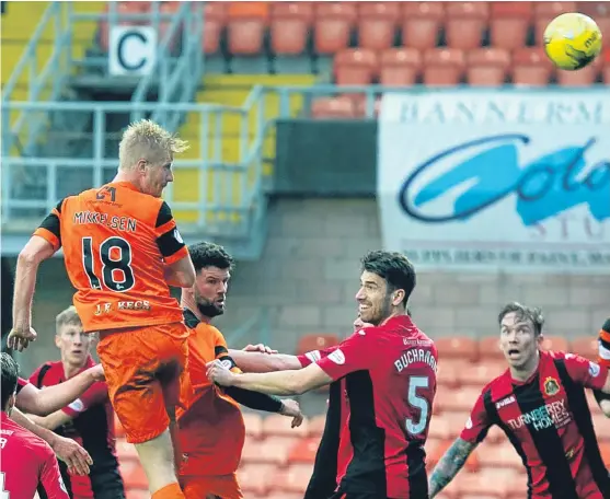  ?? Picture: SNS Group. ?? United striker Thomas Mikkelsen gets up highest but heads a late chance over the Dumbarton bar.