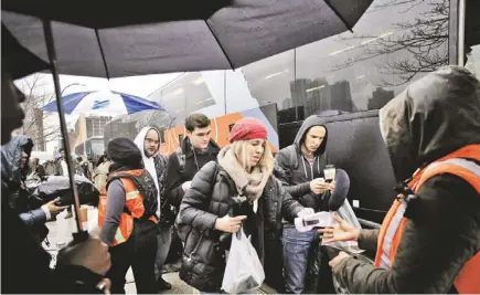  ?? MARK LENNIHAN/AP ?? Passengers board a BoltBus during a light rain Wednesday in New York. So far, the deadly storms barreling into the mid-Atlantic and Northeast resulted in 200 cancellati­ons by airlines.