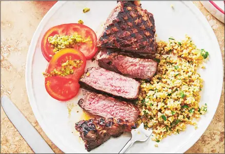  ??  ?? This 2019 photo shows grilled marinated New York strip steak in New York. Marinating is a terrific basic kitchen technique. Essentiall­y, you can take any
kind of meat, fish or seafood, submerge it in a marinade, and you’ve turned a plain something into a great dinner. (AP)