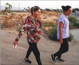  ??  ?? ELVIA GARCIA, left, walks with community organizer Elizabeth Perez in Arvin, Calif., where a gas leak forced Garcia’s family out of their home for nine months.