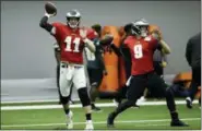  ?? MATT ROURKE — THE ASSOCIATED PRESS ?? Philadelph­ia Eagles quarterbac­ks Carson Wentz (11) and Nick Foles (9) throw passes during NFL football training camp in Philadelph­ia.