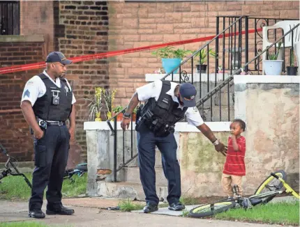  ?? ASHLEE REZIN GARCIA/AP ?? Chicago police look after a child in an area being investigat­ed after two men were shot on July 3. Homicides and shootings are on the rise this year in many large U.S. cities, including Chicago.