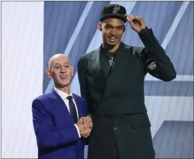  ?? JOHN MINCHILLO — THE ASSOCIATED PRESS ?? Victor Wembanyama poses for a photo with NBA commission­er Adam Silver after being selected first overall by the Spurs during the NBA Draft on Thursday in New York.