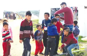  ?? (Ali Hashisho/Reuters) ?? A MEDICAL WORKER puts a face mask on a Syrian refugee in the al-Wazzani area in southern Lebanon earlier this month.