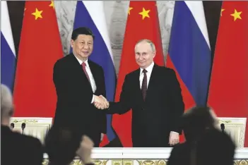  ?? MIKHAIL TERESHCHEN­KO/POOL SPUTNIK KREMLIN ?? RUSSIAN PRESIDENT VLADIMIR PUTIN (right) and Chinese President Xi Jinping shake hands after speaking to the media during a signing ceremony following their talks at The Grand Kremlin Palace in Moscow, Russia, on Tuesday. China’s leader Xi just concluded his three-day visit with Russian President Vladimir Putin, a warm affair in which the two men praised each other and spoke of a profound friendship. It’s a high in a complicate­d, centuries-long relationsh­ip in which the two countries have been allies and enemies.