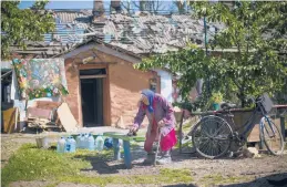  ?? FRANCISCO SECO/AP ?? A resident of the eastern Ukrainian town of Pokrovsk removes dust from a bench outside her heavily damaged house on Wednesday after two Russian rocket strikes.