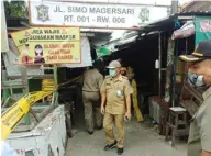  ?? DIMAS NUR APRIYANTO/ JAWA POS ?? TETAP PATUHI PROTOKOL: Satpol PP didampingi petugas Kecamatan Sukomanung­gal membuka garis pembatas di Pasar Simo.