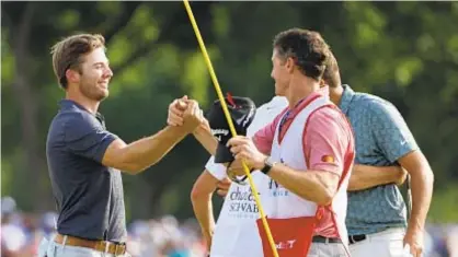  ?? GETTY ?? Sam Burns(l.) celebrates with caddie Travis Perkins after putting in to win Charles Schwab Challenge .