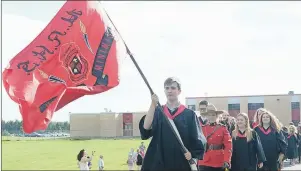  ?? GUARDIAN PHOTO/MITCH MACDONALD ?? Jakob Gosbee carries the Montague Regional High School flag as he leads his fellow graduates from the school to Hillcrest United Church prior to the graduation ceremony.