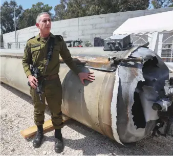  ?? AFP ?? Israeli military spokesman Daniel Hagari poses next to an Iranian ballistic missile which fell in Israel on the weekend, in the southern Israeli city of Kiryat Malachi.