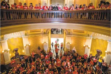  ?? Photos by Jessica Christian / The Chronicle ?? A crowd of teachers, administra­tors and supporters from around the state wearing Red for Ed T-shirts rallies at the Capitol rotunda in Sacramento to demand lawmakers provide more funding for public schools.