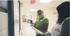  ??  ?? Ebony Lucas, MSF staff wellness officer, right, and Doris Portis, left, director of human resources set up a resource board for Advantage Living Center in Roseville.