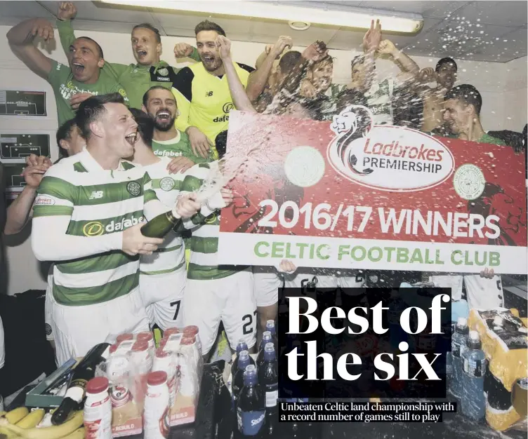  ??  ?? The jubilant Celtic players celebrate with champagne in the away dressing room at Tynecastle after clinching the Premiershi­p title with a comprehens­ive 5-0 win over Hearts.