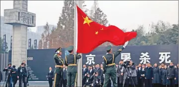  ?? — AFP photo ?? People's Liberation Army (PLA) soldiers raise the Chinese flag during a memorial ceremony at the Nanjing Massacre Memorial Hall on the annual national day of remembranc­e to commemorat­e the 81st anniversar­y of the massacre in Nanjing in China's eastern Jiangsu province on Dec 13.