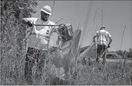  ?? [MEG VOGEL/THE CINCINNATI ENQUIRER] ?? Shawn O’rourke picks up trash alongside Interstate 275 in Batavia on June 26.