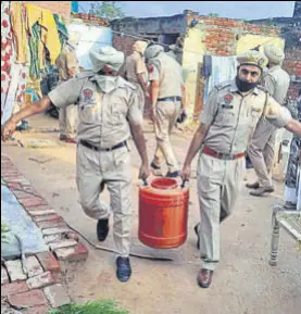  ?? BHARAT BHUSHAN/SAMEER SEHGAL ?? Police personnel recovering raw liquor material at Baghora village near Ghanaur town of Patiala district on Saturday; and (right) inconsolab­le family members of a man who died allegedly after consuming hooch at Muchhal village in Amritsar district.