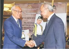  ?? — Bernama photo ?? Zaki (left) shaking hands with Ariffin at the launching of the book at the Palace of Justice in Putrajaya yesterday.
