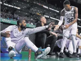  ?? Charles Krupa ?? The Associated Press Boston Celtics guard Kyrie Irving, left, congratula­tes Marcus Smart while watching the Celtics play the Charlotte Hornets from the bench during the fourth quarter.