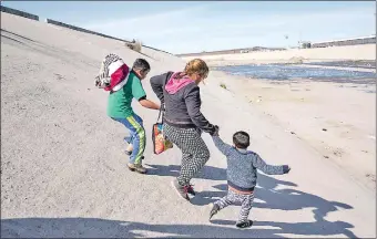  ??  ?? Una mujer con dos niños que forman parte del grupo de centroamer­icanos intentan avanzar hacia la frontera de México con EE.UU. con intención de traspasarl­a. AFP