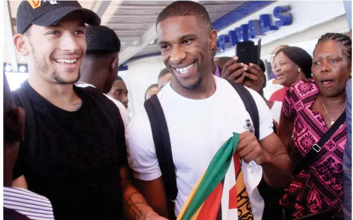  ??  ?? PROUDLY ZIMBABWEAN... Mcauley Bonne (left) and Tendai Darikwa mingle with fans soon after their arrival at Harare Internatio­nal Airport yesterday