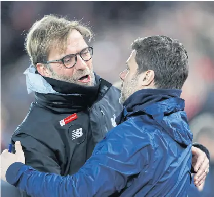  ??  ?? Liverpool manager Juergen Klopp, left, hugs Tottenham boss Mauricio Pochettino before a match at Anfield last year.