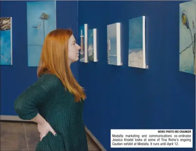  ?? NEWS PHOTO MO CRANKER ?? Medalta marketing and communicat­ions co-ordinator Jessica Knodel looks at some of Tina Riche's ongoing Caution exhibit at Medalta. It runs until April 12.