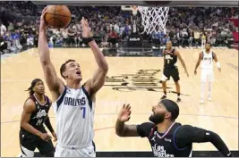  ?? MARK J. TERRILL – THE ASSOCIATED PRESS ?? Dallas center Dwight Powell shoots as Clippers forward Marcus Morris Sr., right, and guard Terance Mann defend during the second half of Wednesday night's Dallas victory.