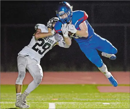  ?? SEAN D. ELLIOT/THE DAY ?? Waterford’s Dan Annibalini makes a catch in front of Guilford’s Miles Gabriel (29) during Friday night’s 28-14 loss to the Indians.