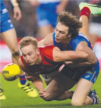  ?? Picture: GETTY IMAGES ?? Bernie Vince of the Demons is tackled by the Bulldogs’ Liam Picken during yesterday’s one-sided match at Etihad Stadium.