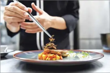  ??  ?? Edible winged ants are placed on a fish fillet inside the kitchen of Insects in the Backyard, which says it offers the first insect-based fine-dining menu, on August 15 in Bangkok. Bugs are creeping onto the menu of some of Bangkok’s high-end...